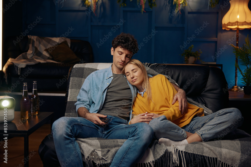 Loving couple fell asleep on a couch while watching a movie Loving couple fell asleep on a couch while watching a movie