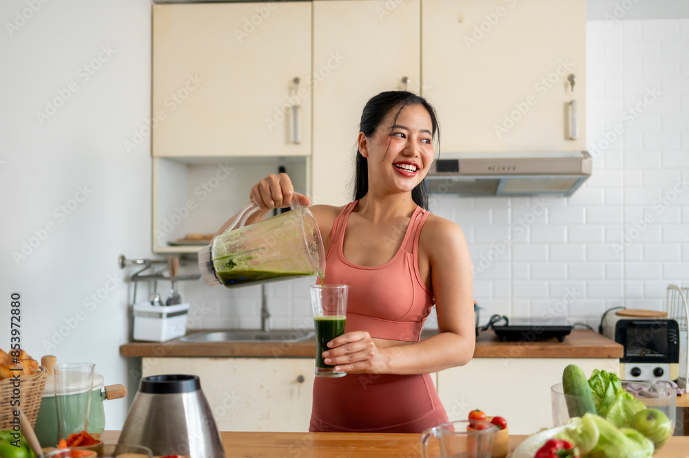 A woman is making a green smoothie in a kitchen A woman is making a green smoothie in a kitchen