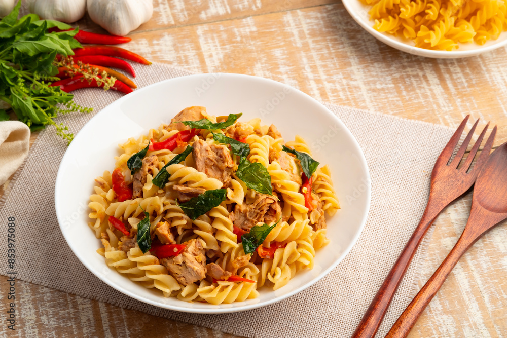 Stir fried trivelle pasta with Canned tuna fish and crispy basil leaves in white plate,Spicy pasta Pad Kra Pao.Thai fusion food Stir fried trivelle pasta with Canned tuna fish and crispy basil leaves in white plate,Spicy pasta Pad Kra Pao.Thai fusion food