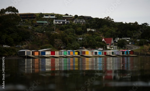 Historic colorful wooden boat sheds on Duvauchelle Bay shore in Akaroa Harbour, Banks Peninsula, Canterbury, New Zealand photo