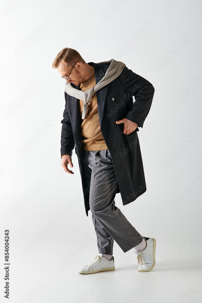 A stylishly dressed man confidently strides in a trench coat. A stylishly dressed man confidently strides in a trench coat.