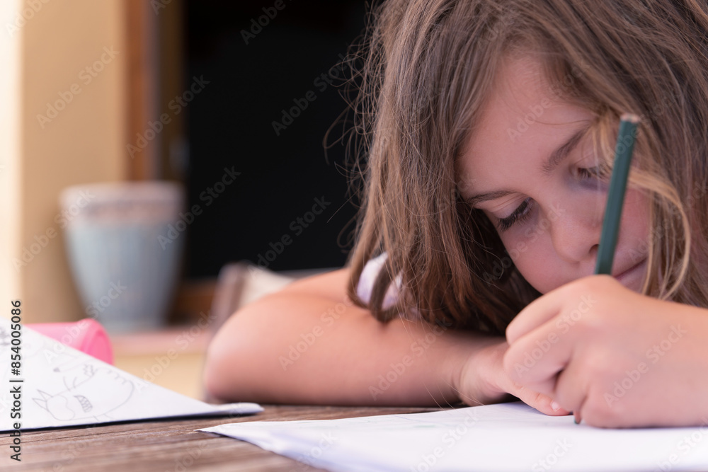 close-up of a beautiful blonde girl concentrating on drawing in a notebook close-up of a beautiful blonde girl concentrating on drawing in a notebook