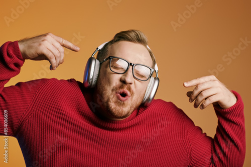 Stylish man with glasses and headphones making a funny face.