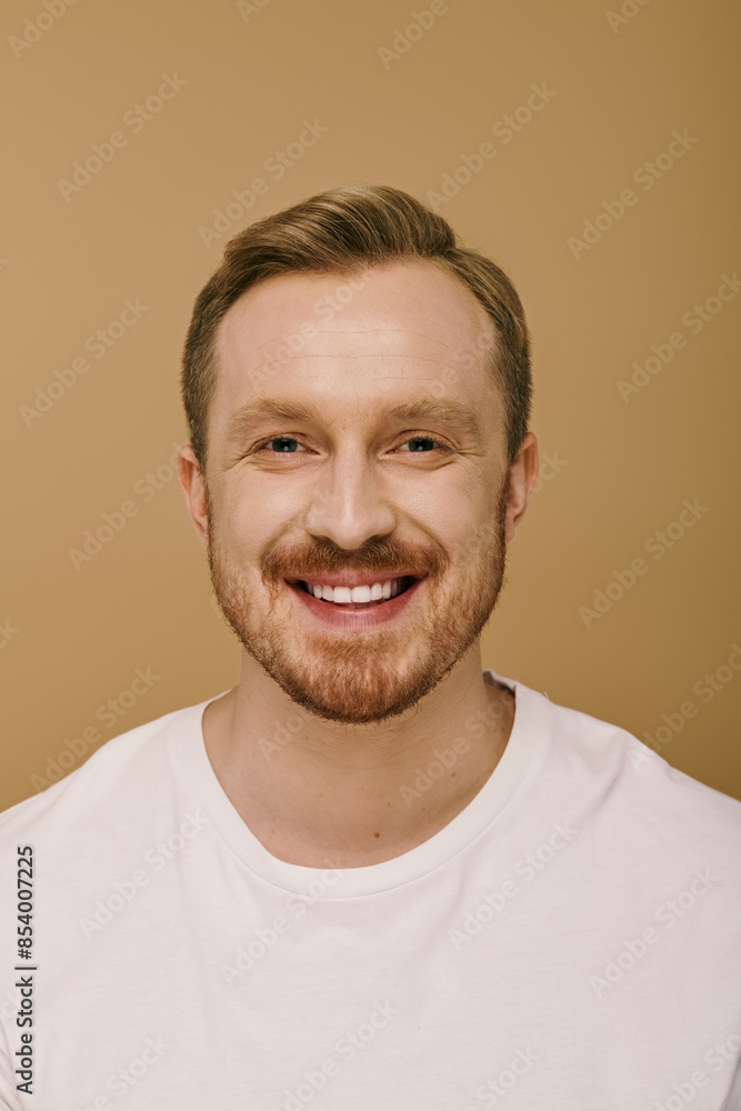 Obraz premium A stylish man with a beard smiles brightly.