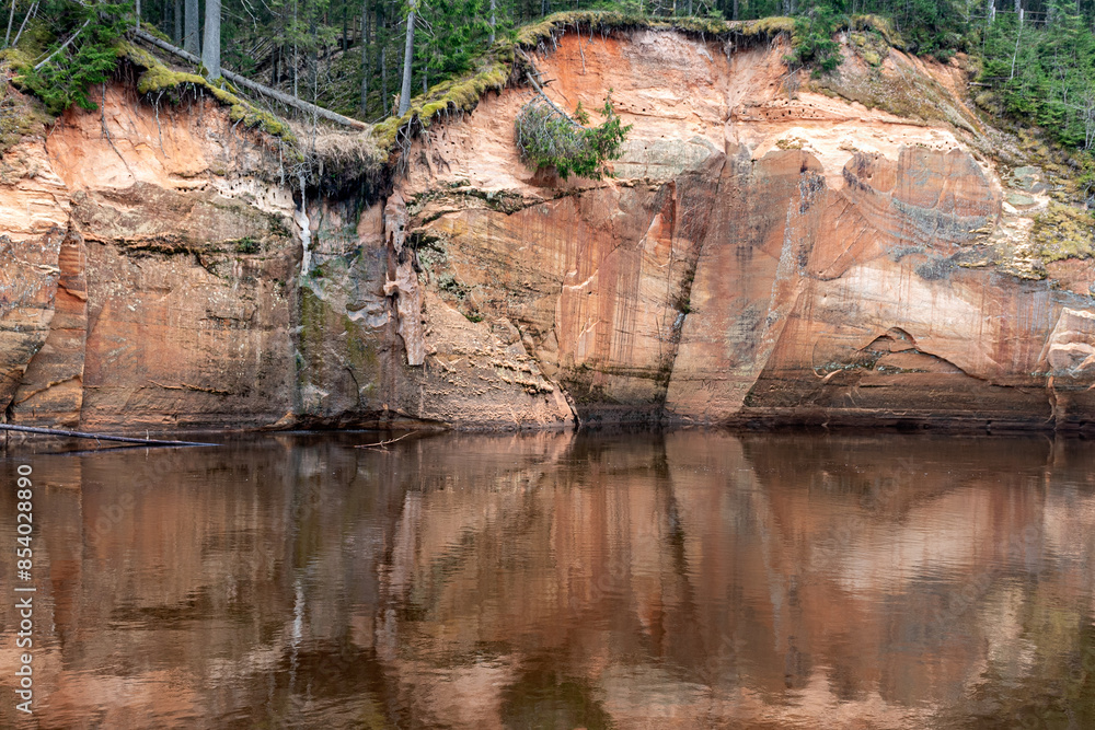 landscape with sandstone cliffs on the river bank, sandy river bank, old last year's grass, nature without greenery, Erglu cliffs, Cesu county, Latvia landscape with sandstone cliffs on the river bank, sandy river bank, old last year's grass, nature without greenery, Erglu cliffs, Cesu county, Latvia