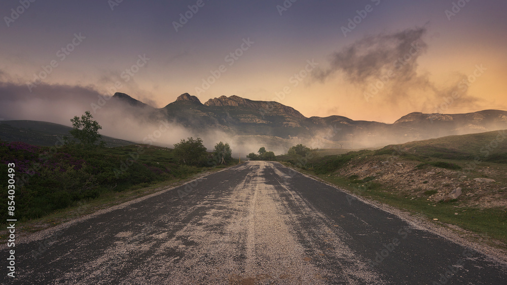 Naklejka premium carretera de montaña en primer plano nos guía hacia los montes del fondo en Lunada, Burgos