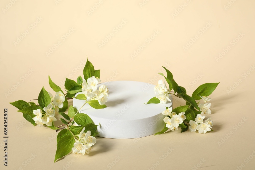 Presentation of product. White podium and beautiful jasmine flowers on beige background, space for text Presentation of product. White podium and beautiful jasmine flowers on beige background, space for text