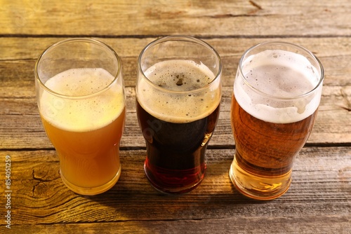 Bild auf Leinwand Glasses with different types of beer on wooden table