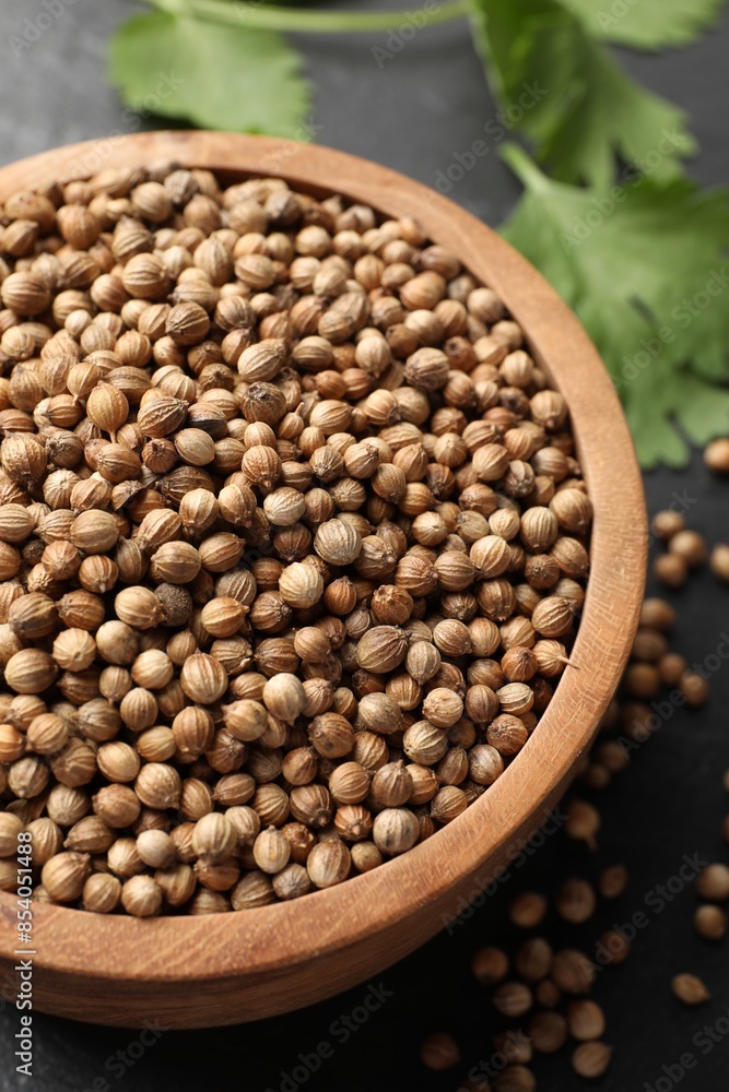 Dried coriander seeds in bowl on gray table, closeup Dried coriander seeds in bowl on gray table, closeup