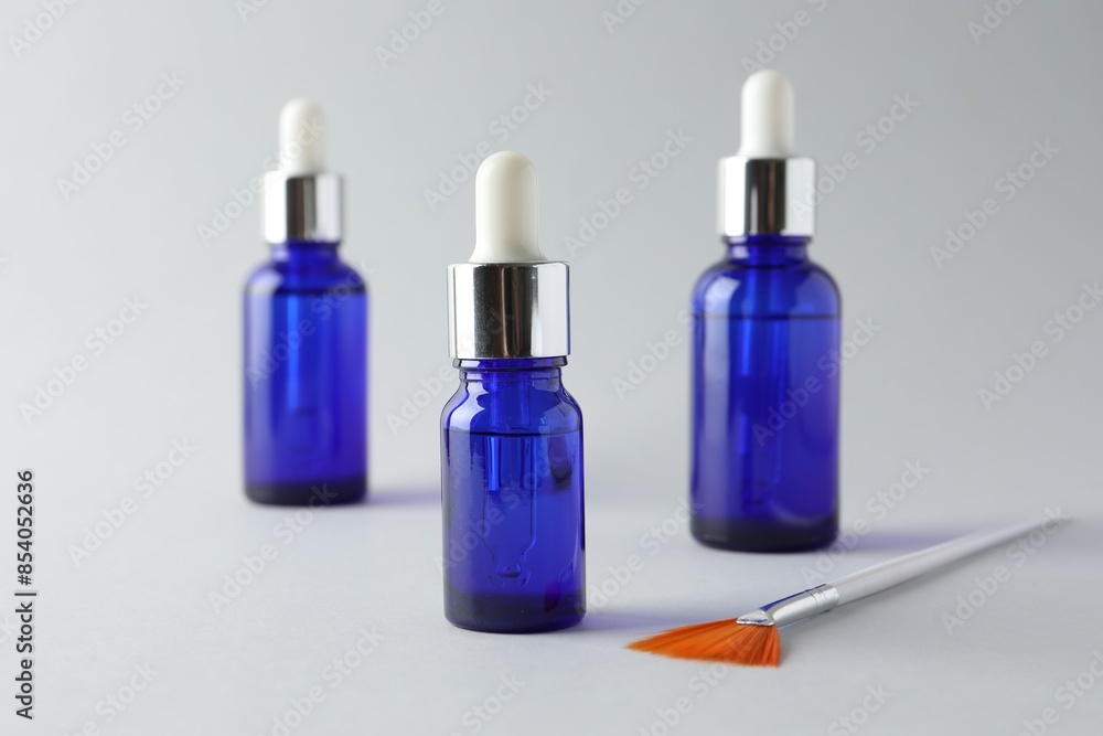 Bottles of chemical peel and brush on light background, closeup. Peeling procedure Bottles of chemical peel and brush on light background, closeup. Peeling procedure