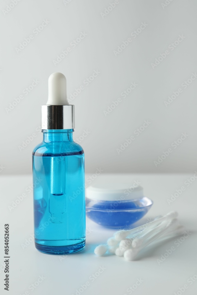 Bottle of chemical peel liquid, jar and cotton swabs on light background. Peeling procedure Bottle of chemical peel liquid, jar and cotton swabs on light background. Peeling procedure
