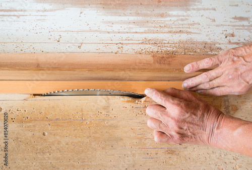 The hand working with the rotating saw blade is high speed and dangerous. photo