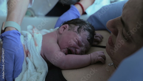 Obraz na plátně First seconds of life of a newborn baby right after birth struggling to take his