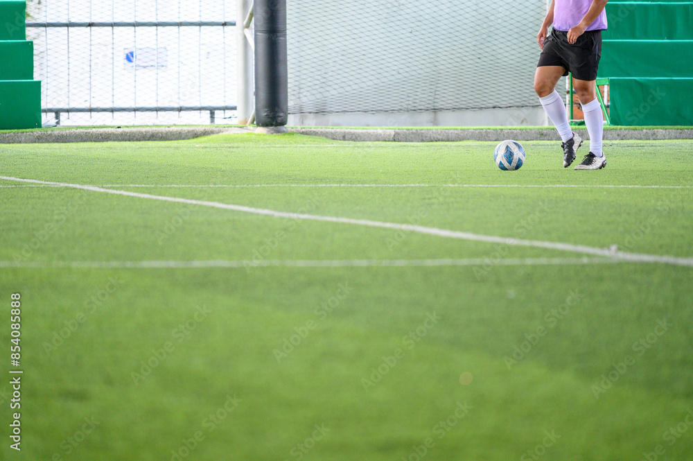 Soccer players in action during a game on a grass field, focusing on their legs and the ball. Soccer players in action during a game on a grass field, focusing on their legs and the ball.