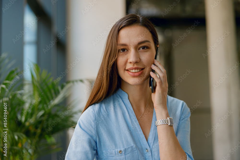Professional businesswoman talking on the phone in her office, engaged in business communication Professional businesswoman talking on the phone in her office, engaged in business communication