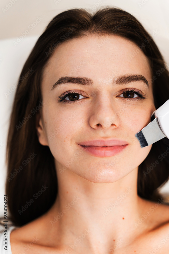 Exfoliation of dead skin on face with special ultrasound hardware. Cavitation peeling process in cosmetology clinic. Exfoliation of dead skin on face with special ultrasound hardware. Cavitation peeling process in cosmetology clinic.