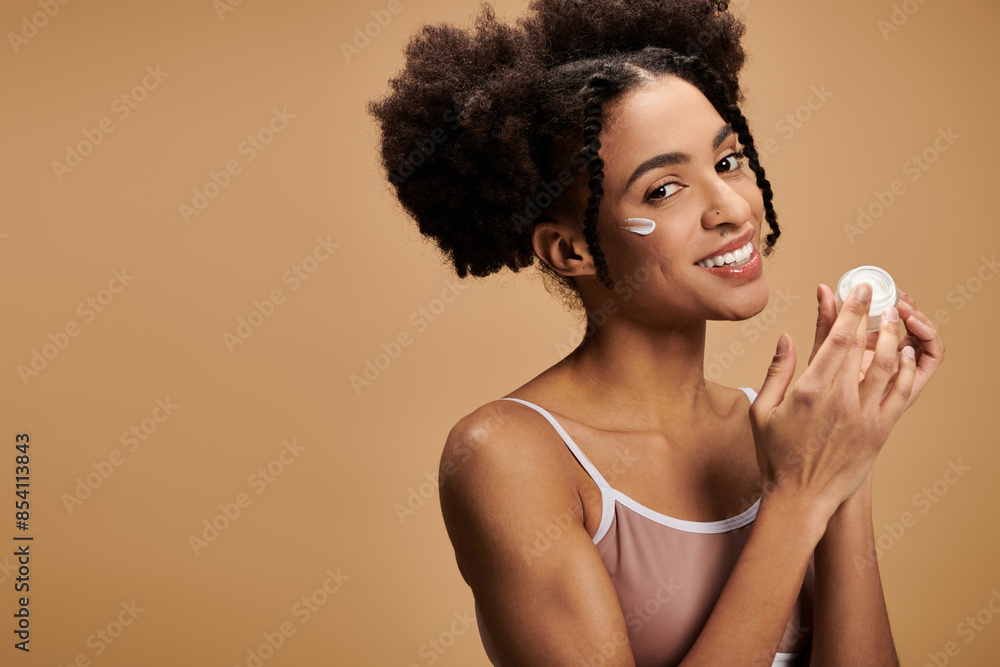 A young African American woman smiles confidently while applying facial moisturizer, highlighting the beauty of diverse skin tones. A young African American woman smiles confidently while applying facial moisturizer, highlighting the beauty of diverse skin tones.