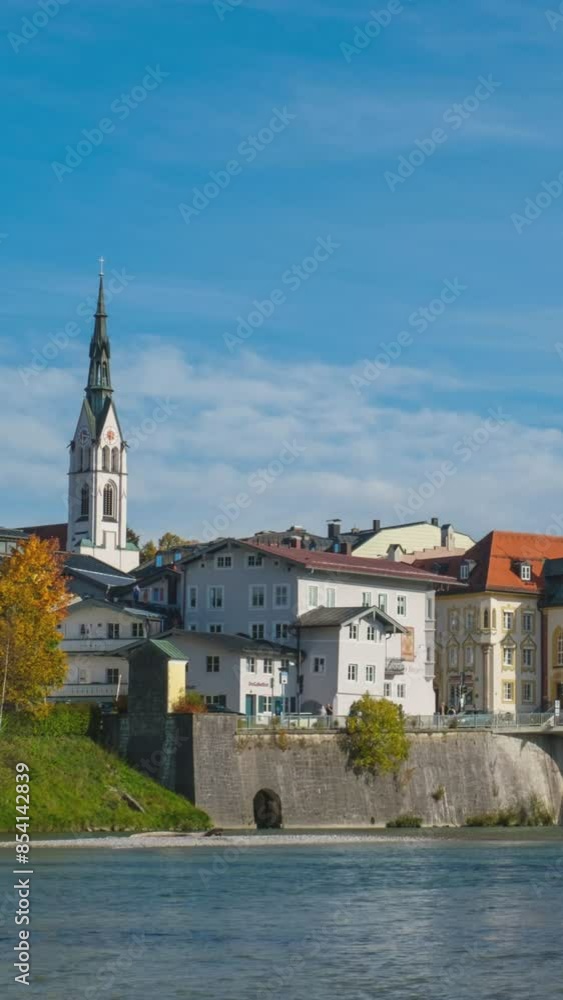 Time lapse of golden autumn in famous tourist landmark town Bad Tolz. Landscape view of Isar river, trees, town bridge, idyllic Bavarian houses and Church. Bad Toelz, Bavaria, Germany. Camera pan Time lapse of golden autumn in famous tourist landmark town Bad Tolz. Landscape view of Isar river, trees, town bridge, idyllic Bavarian houses and Church. Bad Toelz, Bavaria, Germany. Camera pan