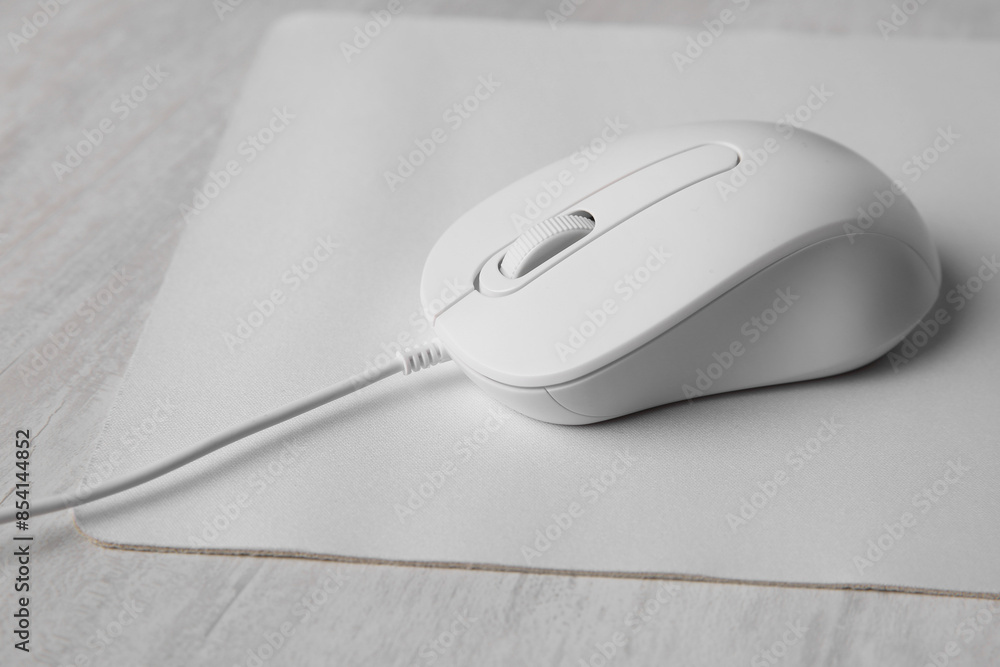 Wired mouse with mousepad on grey wooden table, closeup Wired mouse with mousepad on grey wooden table, closeup