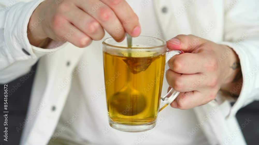 Green tea in a transparent cup.
A man stirs tea with a teaspoon.
Hot tea with takane Green tea in a transparent cup.
A man stirs tea with a teaspoon.
Hot tea with takane