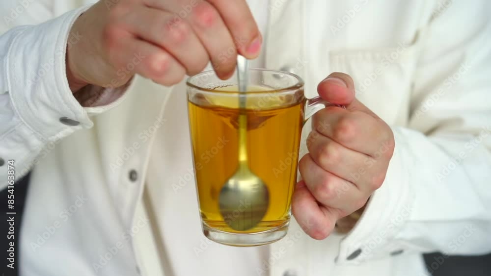 A man with a glass cup in his hands drinks tea.
Green tea in a transparent glass A man with a glass cup in his hands drinks tea.
Green tea in a transparent glass