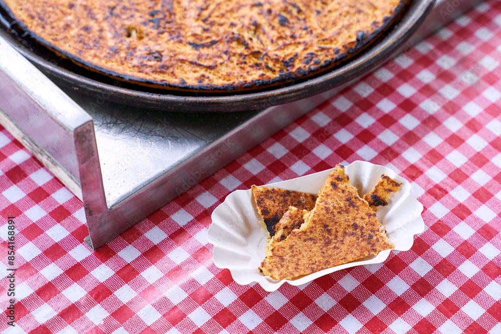 Socca, just coming out of the oven, in Nice, the French Riviera. a type of thin, Socca is a specialty of southeastern French cuisine. a pancake made from chickpea flour.