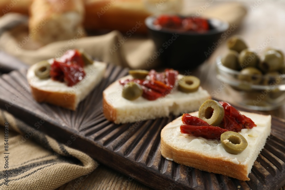 Delicious bruschettas with ricotta cheese, sun dried tomatoes and olives on table, closeup Delicious bruschettas with ricotta cheese, sun dried tomatoes and olives on table, closeup