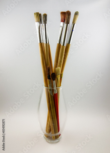 set of brushes in a glass vase