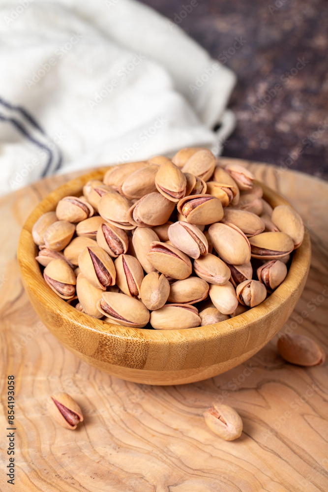 Pistachios on wooden background. Pistachios in a bowl Pistachios on wooden background. Pistachios in a bowl