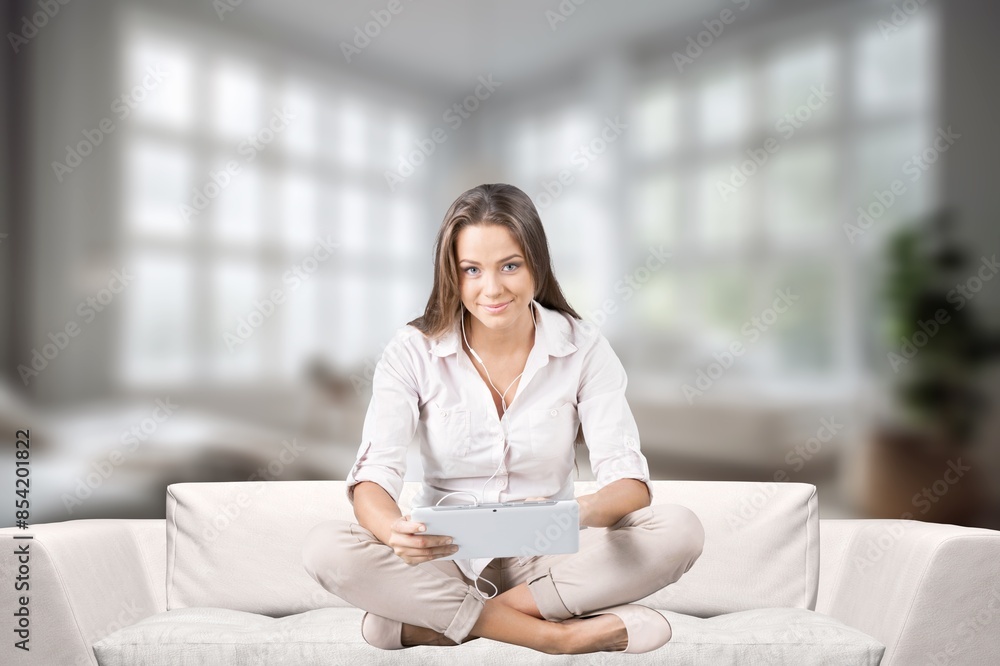 Obraz premium Smiling young girl sitting using gadget
