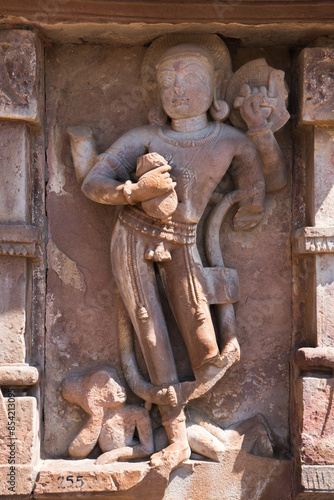 A statue portraying a man with a serpent coiled around his midsection, Ancient Indian Menal Shiv Temple photo