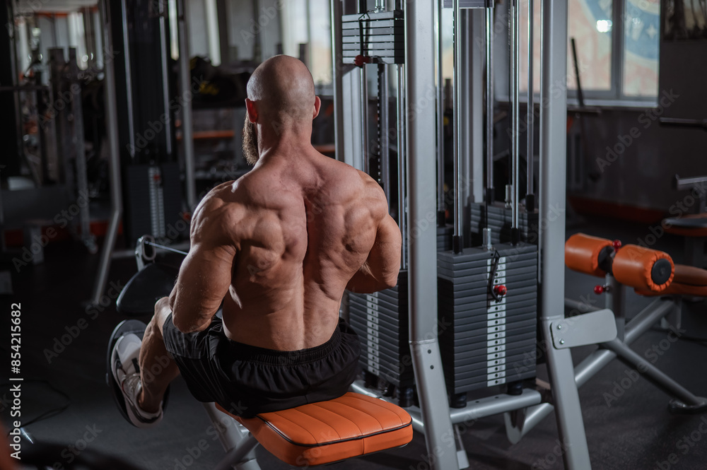Naklejka premium Caucasian man doing rowing exercises on a rowing machine. 