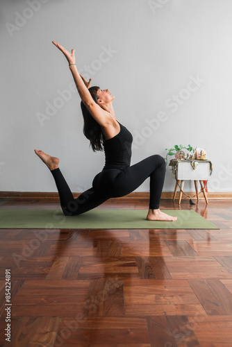 Slender woman practicing a variation of the low Lunge yoga pose. photo