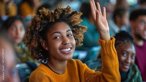 Happy African American student raising her hand to ask a question during lecture in the classroom.
