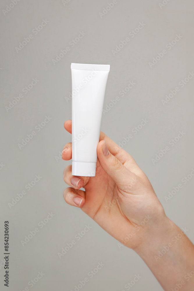 Female hand holding a tube of cream.Woman's hand showing cream tube ...