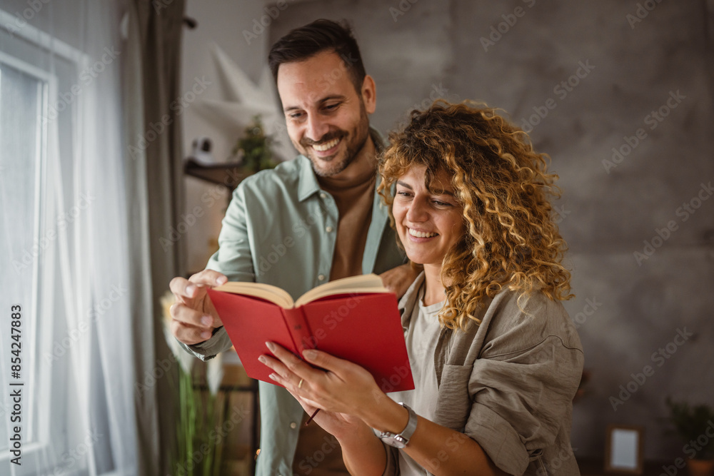 Girlfriend read a book while his boyfriend hug her at home Girlfriend read a book while his boyfriend hug her at home