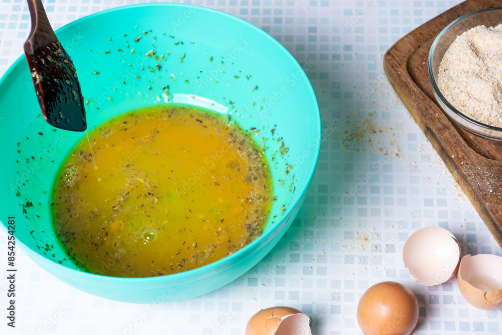 Egg beaten with garlic and parsley for pork breading. Egg beaten with garlic and parsley for pork breading.