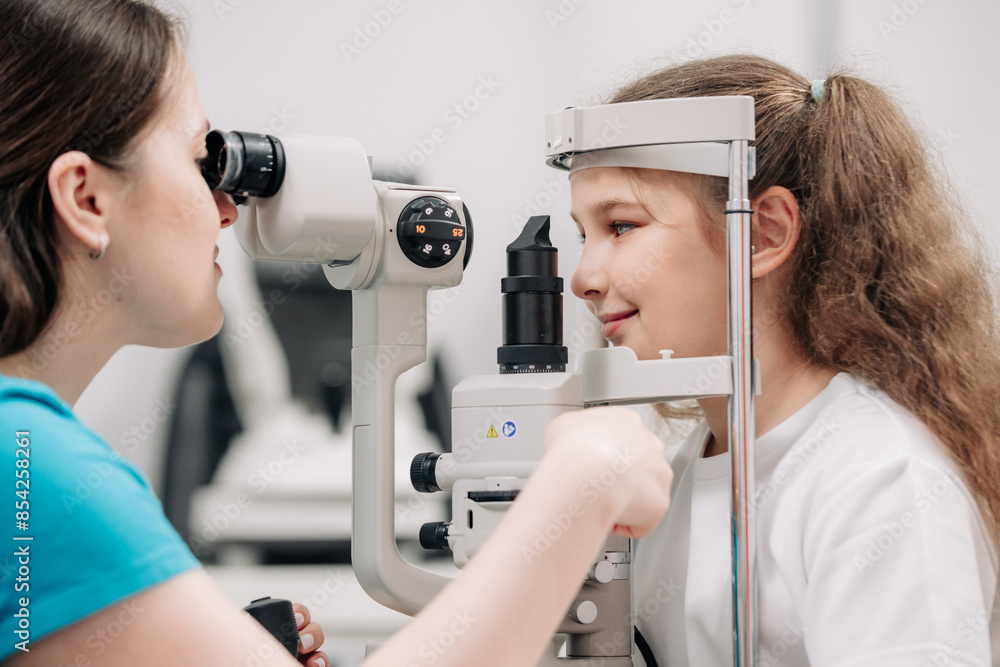 Examination of the child using a slit lamp. Microscope and focused light source. A device for high-precision examination of the eye to determine the condition of the lens. Examination of the child using a slit lamp. Microscope and focused light source. A device for high-precision examination of the eye to determine the condition of the lens.