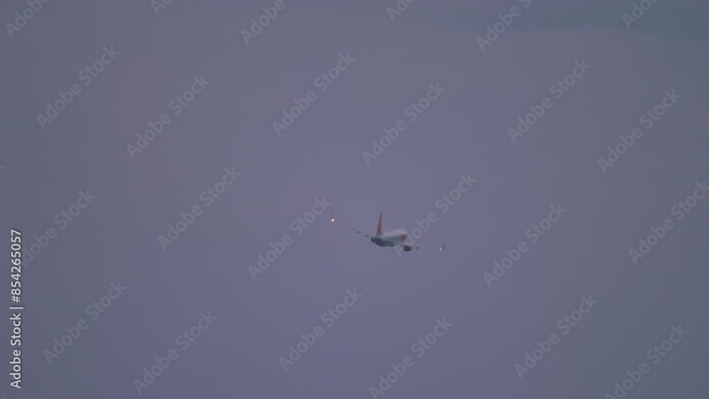 Long shot, airplane taking off and climbing at Phuket airport at dawn or sunset, at dusk. Plane flying, rear view Long shot, airplane taking off and climbing at Phuket airport at dawn or sunset, at dusk. Plane flying, rear view