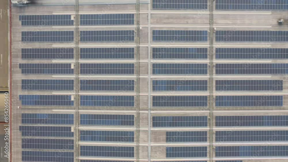 Aerial view of solar panels or solar cells on the roof of factory building rooftop. Power plant, renewable clean energy source. Eco technology for electric power in industry. Aerial view of solar panels or solar cells on the roof of factory building rooftop. Power plant, renewable clean energy source. Eco technology for electric power in industry.