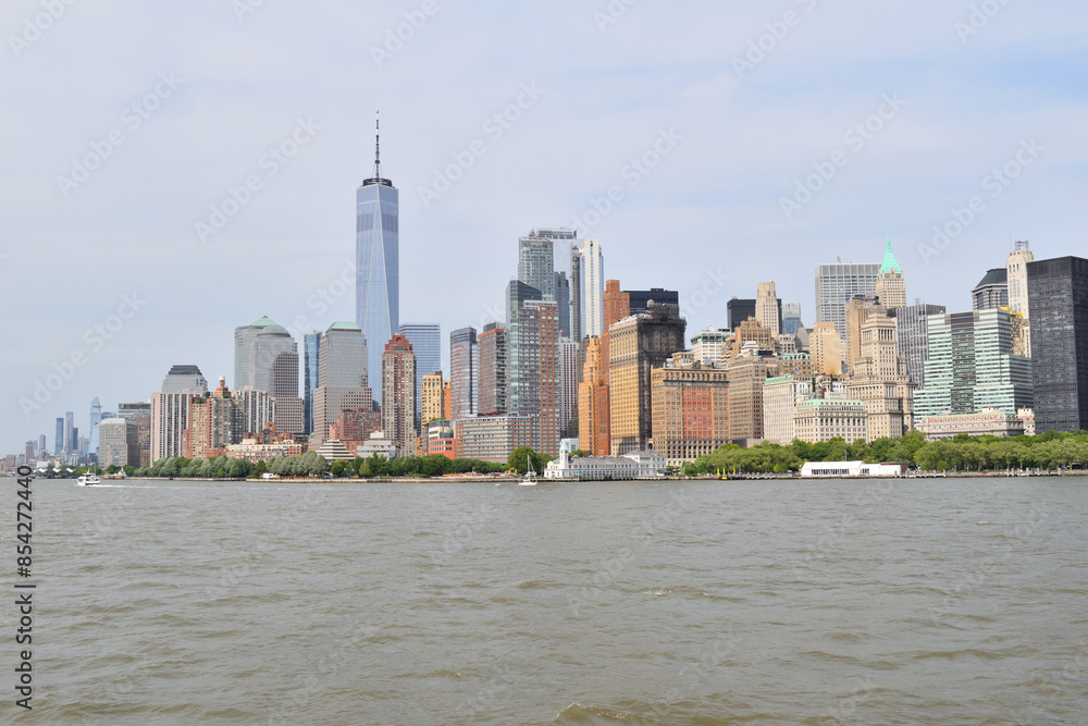 Obraz premium A city skyline with the New York City skyline in the background. The water is calm and the sky is clear