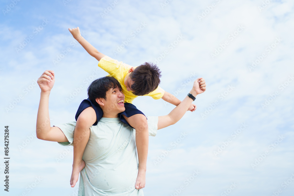 Asian father and son playing together, a man piggyback the boy on his back. Asian father and son playing together, a man piggyback the boy on his back.