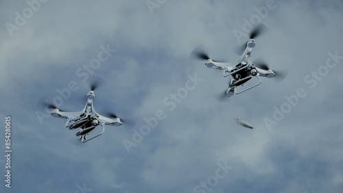 Two military quadcopter drones dropping two bombs after detecting a target with the camera