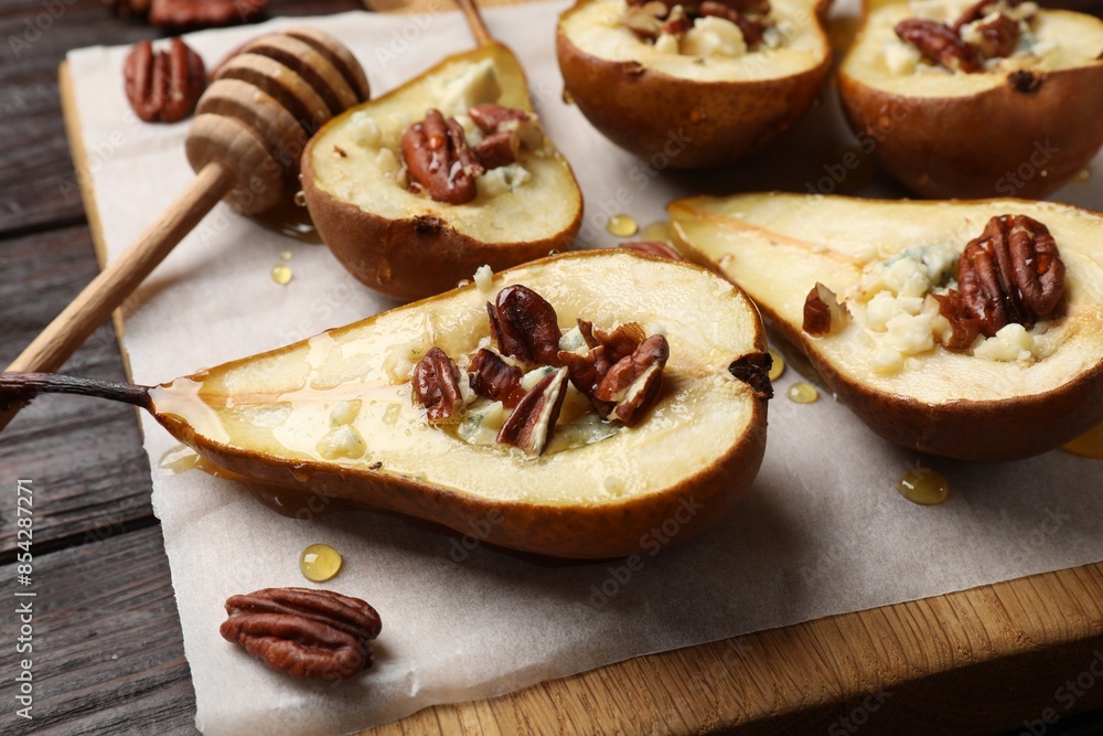 Tasty baked pears with nuts, blue cheese, thyme and honey on wooden table, closeup Tasty baked pears with nuts, blue cheese, thyme and honey on wooden table, closeup