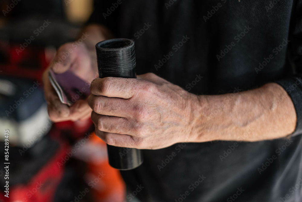 Plumber's hands using sandpaper on pvc pipe Plumber's hands using sandpaper on pvc pipe