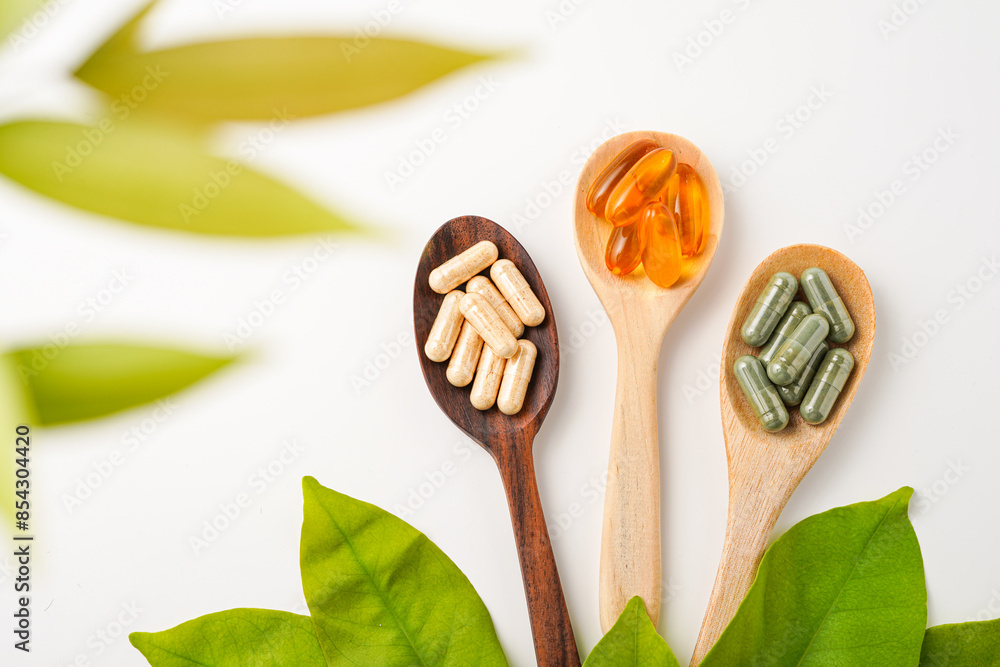 Vitamin capsules in a wooden spoon, soft gels, Fish oil capsules, omega 3, omega 9, vitamin D, vitamin E Vitamin capsules in a wooden spoon, soft gels, Fish oil capsules, omega 3, omega 9, vitamin D, vitamin E