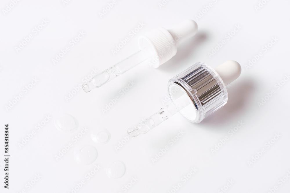 Pipettes with moisturizing serum on white background top view. Pipettes with moisturizing serum on white background top view.