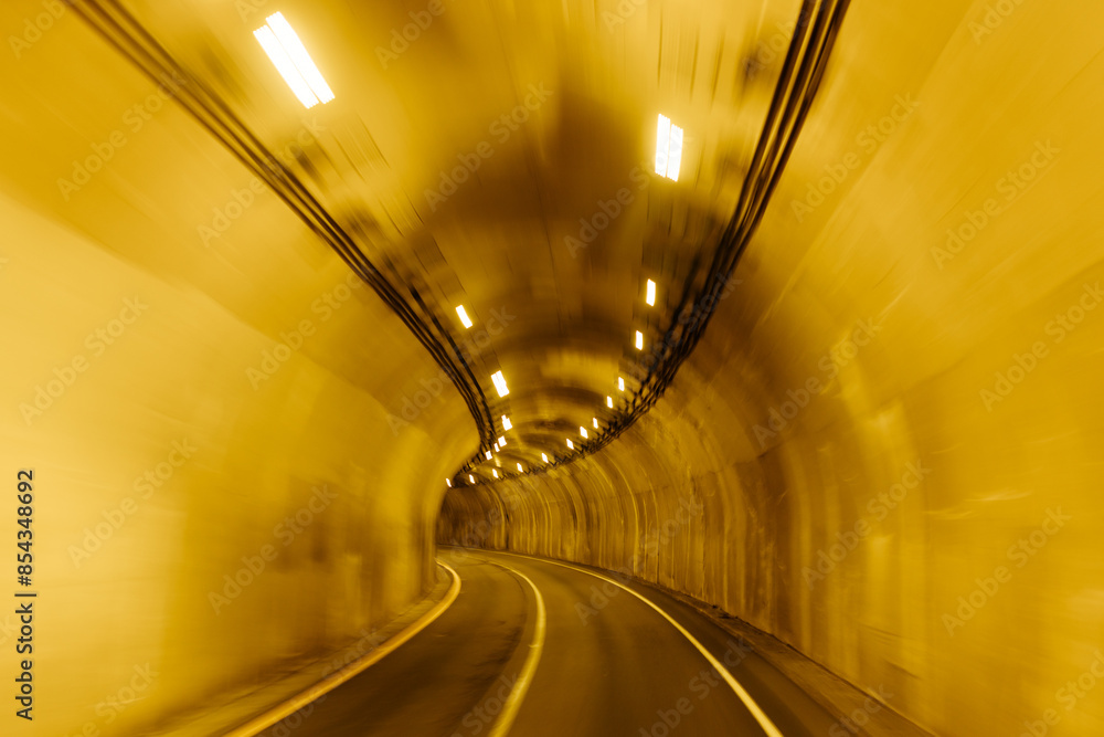 A long tunnel among the mountains. A light in the end of a tunnel. Industrial landscape. Asphalt road in the mountains. Highway. Driving through a tunnel among the mountains on a sunny summer day. A long tunnel among the mountains. A light in the end of a tunnel. Industrial landscape. Asphalt road in the mountains. Highway. Driving through a tunnel among the mountains on a sunny summer day.