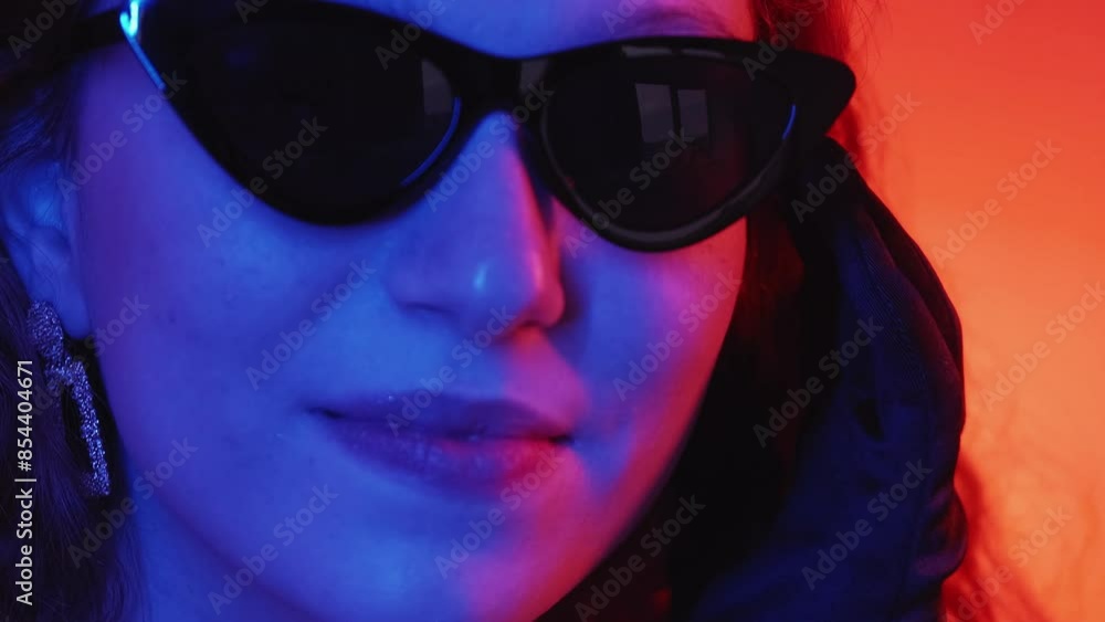Glamour woman. Sunglasses fashion. Stylish confident female taking off eyewear flirty winking luxurious look red neon light gradient background. Glamour woman. Sunglasses fashion. Stylish confident female taking off eyewear flirty winking luxurious look red neon light gradient background.