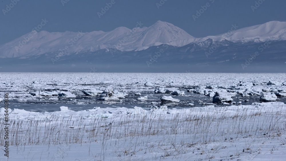 Naklejka premium winter landscape with Shiretoko Mountain Range and ice floe in Hokkaido, Japan